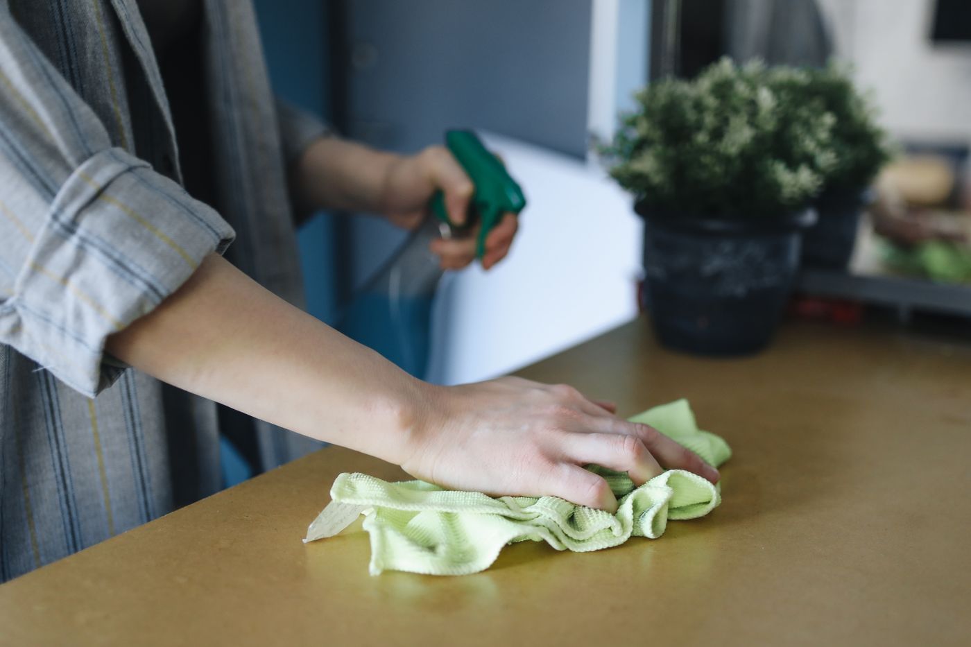 Cleaner wiping a kitchen surface with cloth and spray in a Doncaster home