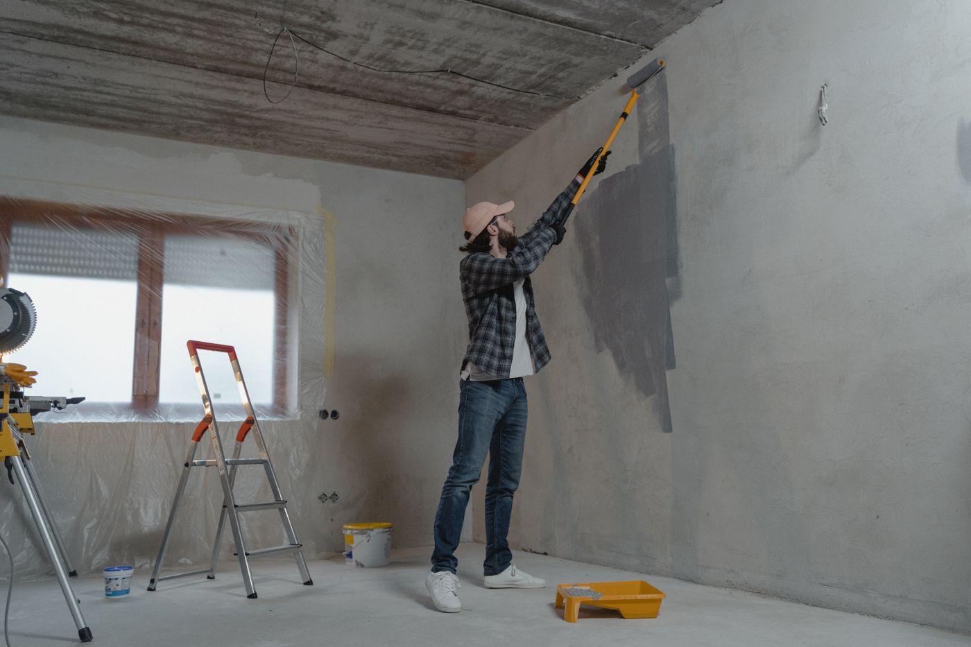 Painter applying fresh paint to an interior wall with a roller in Doncaster